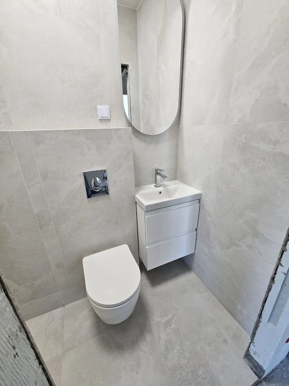 Wykończone WC w szarych płytkach z podwieszaną miską i umywalką